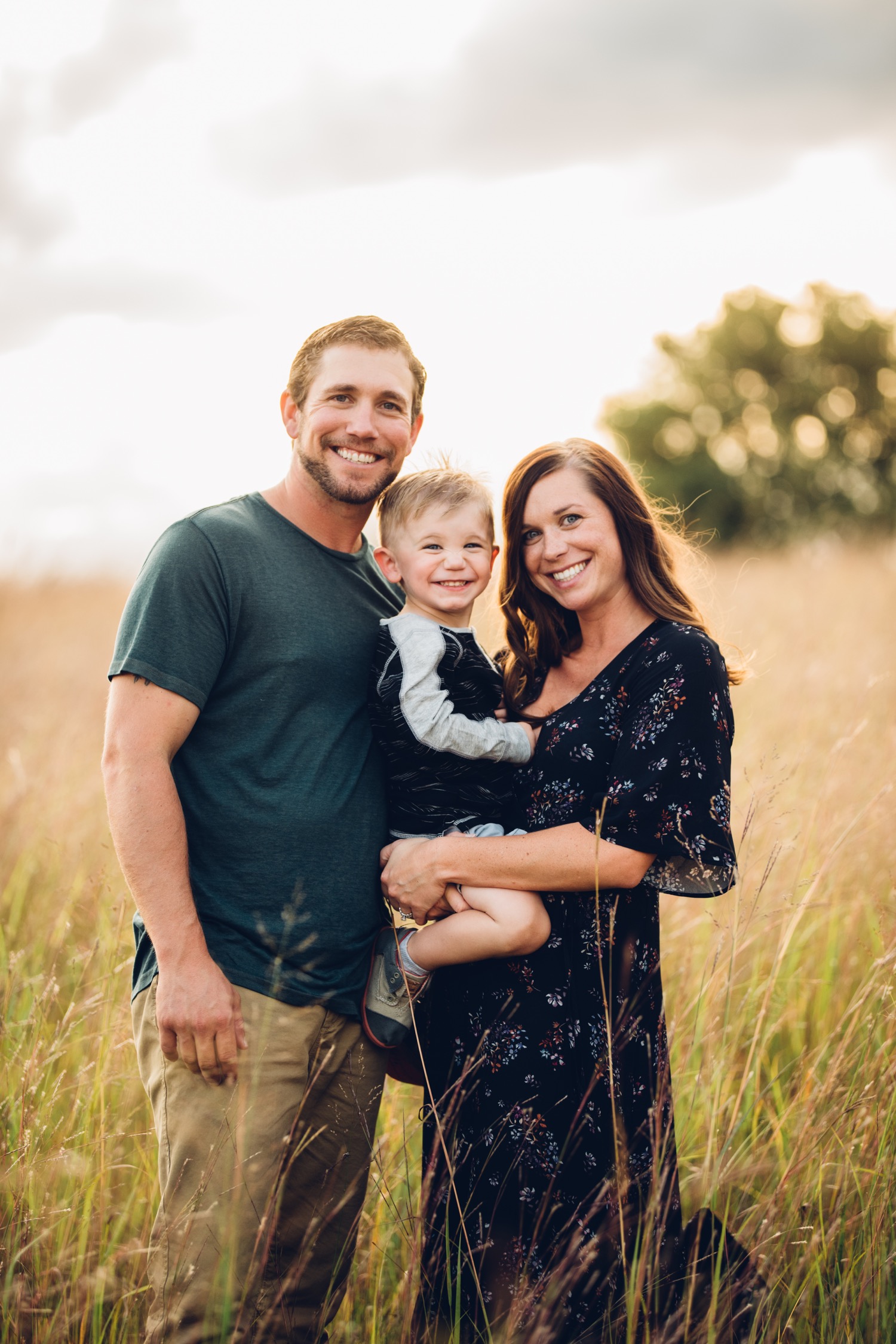 Family of 3 in a field during minnesota family portrait session